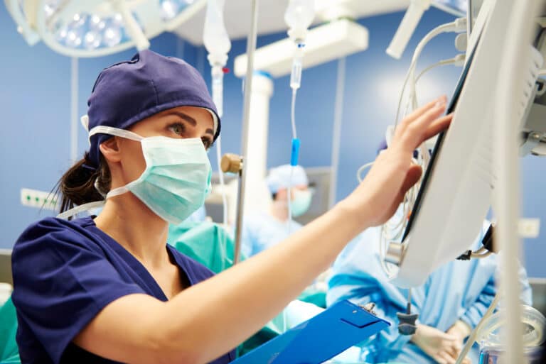 Operating room nurse viewing tech equipment