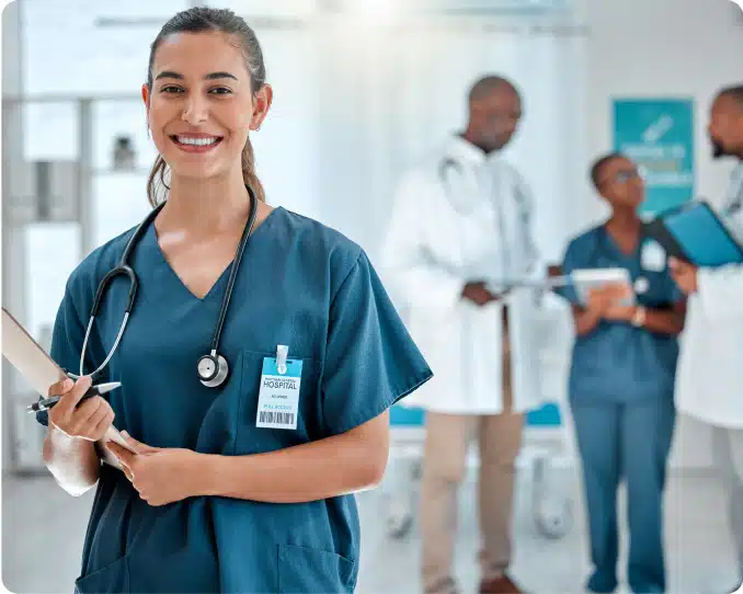 Young nurse standing with clipboard in hospital setting, with doctors and nurses in the background