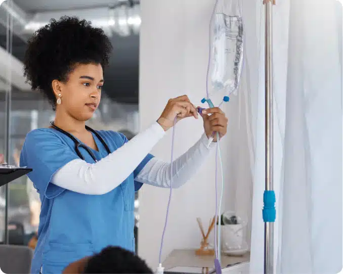 Young nurse checking IV bag connection in hospital