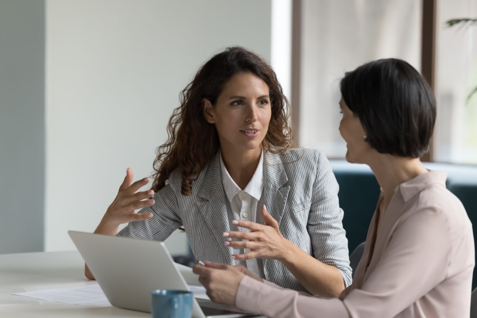 Allied Health Staffing Solutions with TRS Managed Services Two businesswomen sitting at a desk with a laptop in discussion