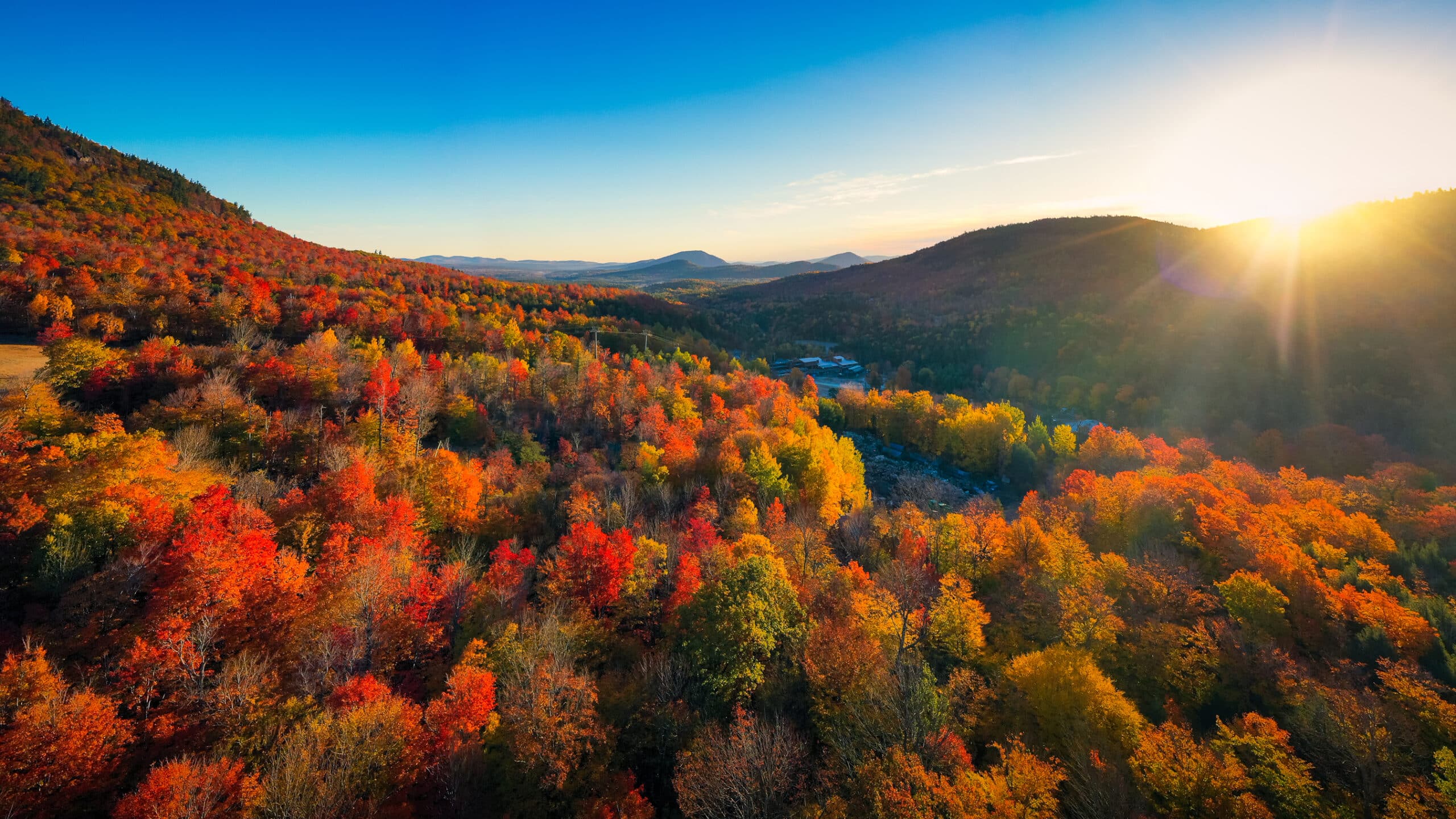 Travel Healthcare Jobs in New York Aerial view of Mountain Forests with Brilliant Fall Colors in Autumn at Sunrise, Adirondacks, New York, New England
