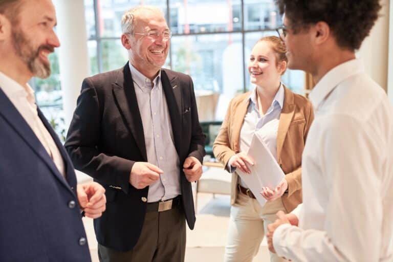 Group of businesspeople standing together, laughing